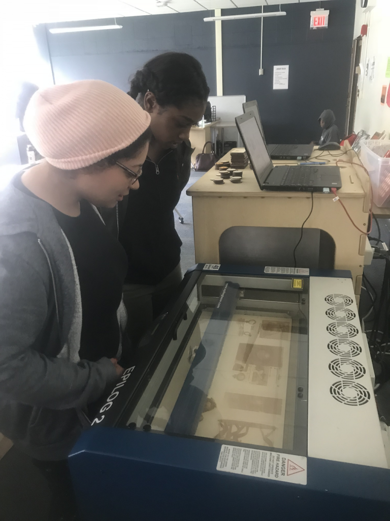 Students and teachers watching 3d printer work. Courtesy of the author.